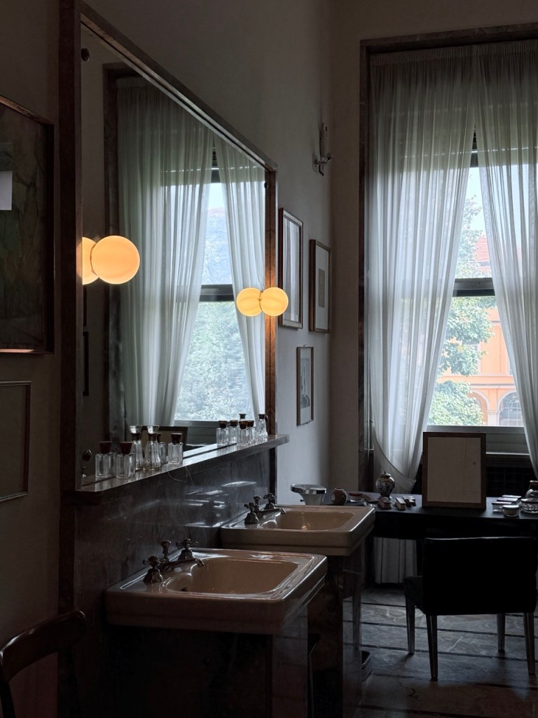 Interior image of Villa Necchi Campiglio, showcasing a spacious bathroom with a large wash basin and mirror.