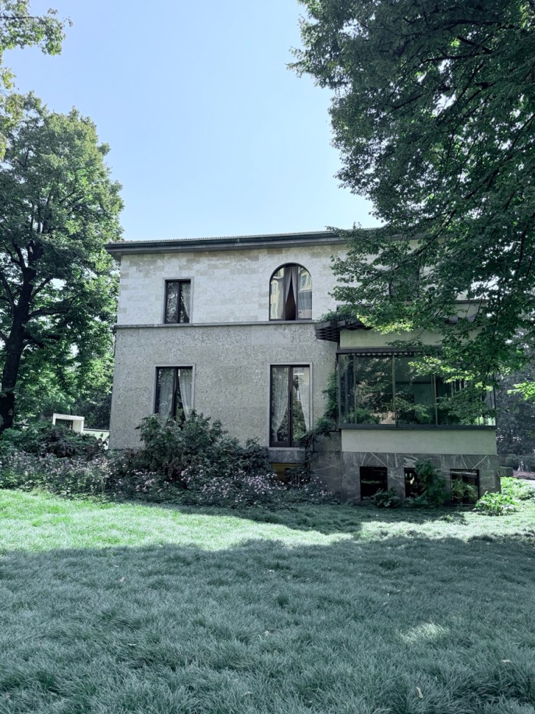 Exterior image of Villa Necchi Campiglio, showcasing the building nestled within its lush garden surroundings.